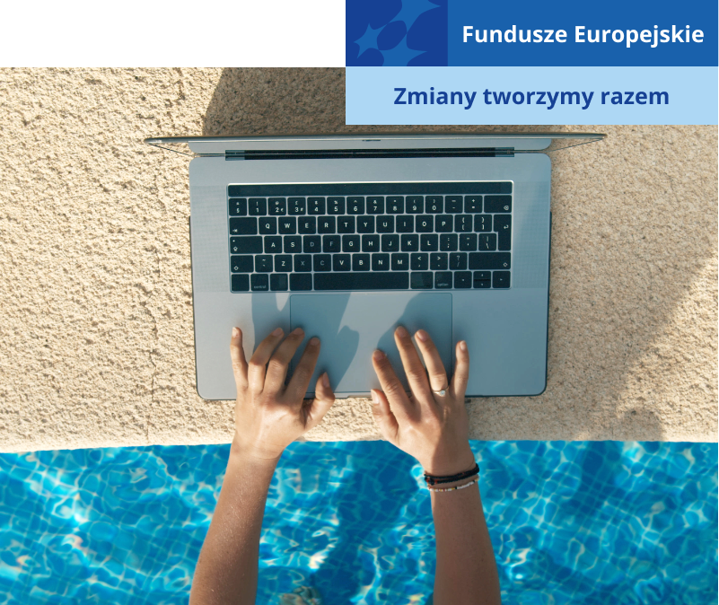Fotografia przedstawia osobę, która korzysta z laptopa, będąc w basenie. Komputer ustawiony jest na brzegu basenu. Widoczne są ręce osoby go obsługującej.