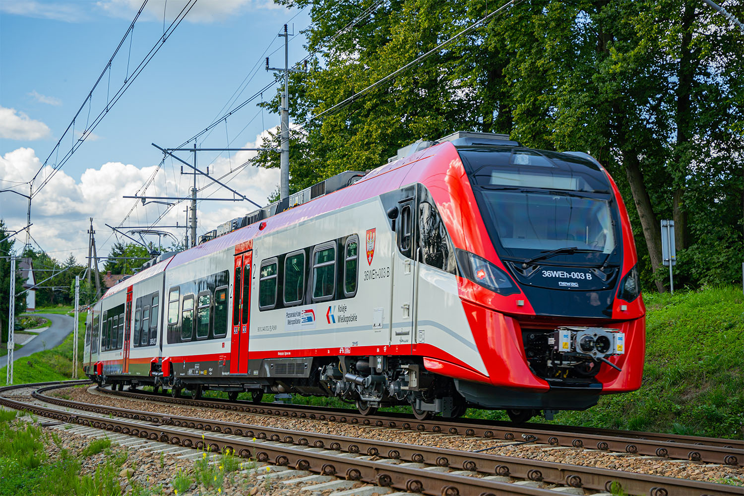 Na zdjęciu pociąg w barwach biało-czerwonych, który jedzie po torach