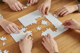 ludzie układają puzzle
