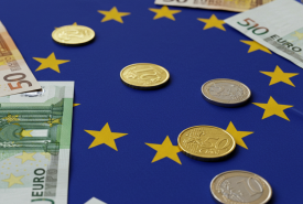na tle flagi unii europejskiej banknoty i monety